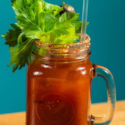 Virgin Bloody Mary served in a mason jar, garnished with  a large stalk of celery.