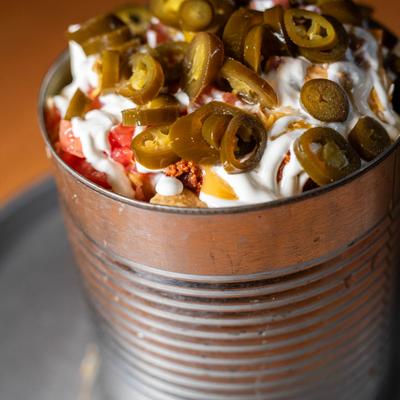 Nachos layered in a tin bucket.