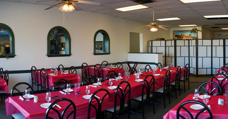 Long tables with red tablecloths set for dining
