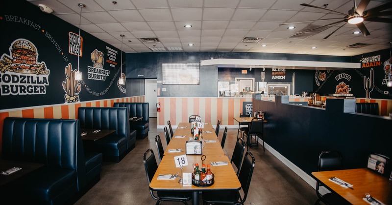 Modern diner-style interior with booth benches and tables with chairs arranged in the center