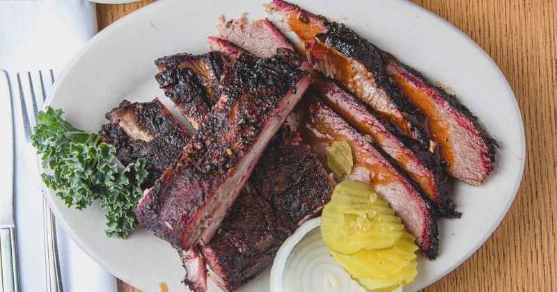 Grilled meat, lemon and green spices on the side