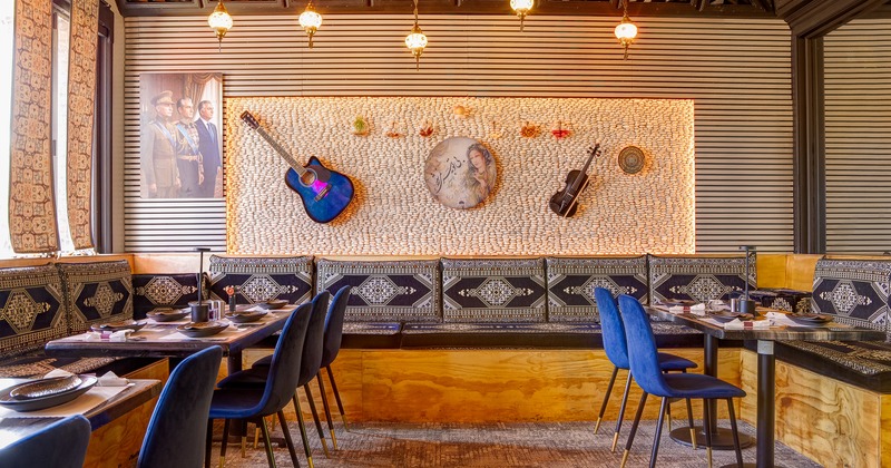 Cozy interior dining area with traditional design elements, blue velvet chairs and set tables