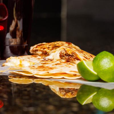 Quesadilla sliced and served with lime wedges.
