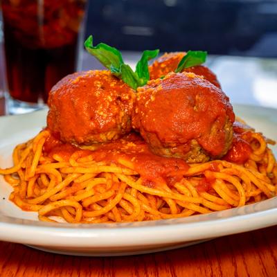Spaghetti topped with meatballs, tomato sauce and basil.