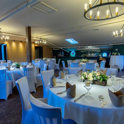 Banquet hall with wood accents, dim lighting, and modern décor set up for a party or event.