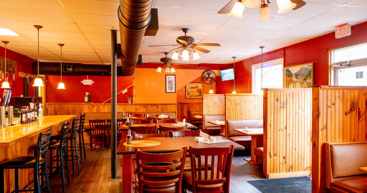 Interior with bar seating, tables and booths, wooden decor and red walls