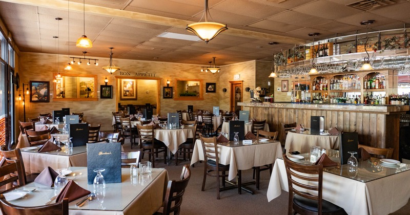 Interior, dining area, set up tables with wooden chairs, classy chandeliers, bar