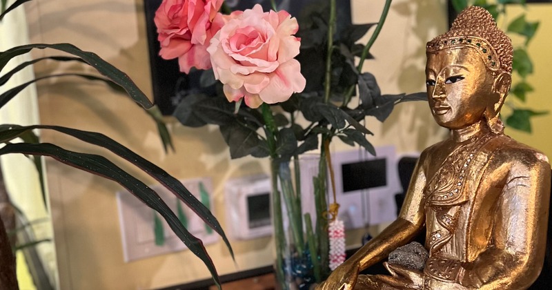 Interior, decoration detail, rose arrangement and a Buddha statue