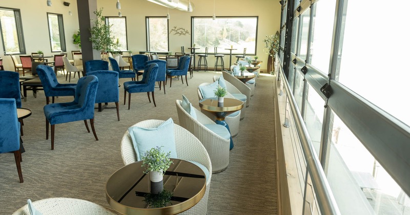 Interior, wicker chairs by the window, tables for two