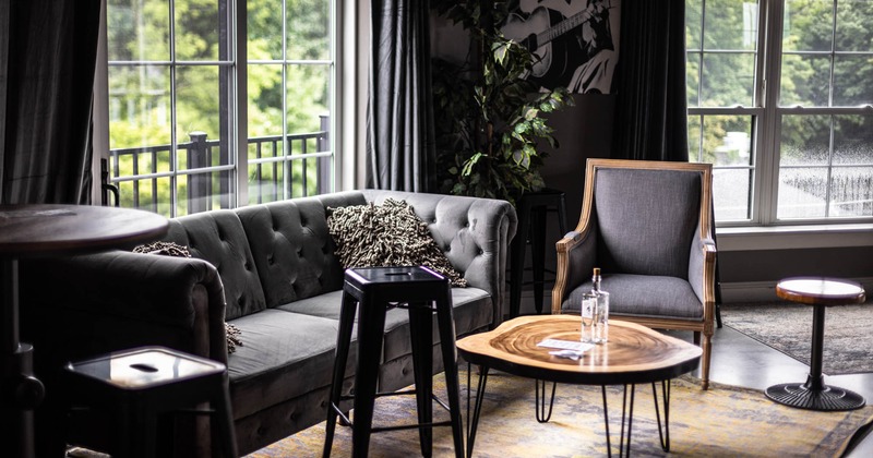 Interior, sofa seating  with pillow, arm chair and a coffee table by a window