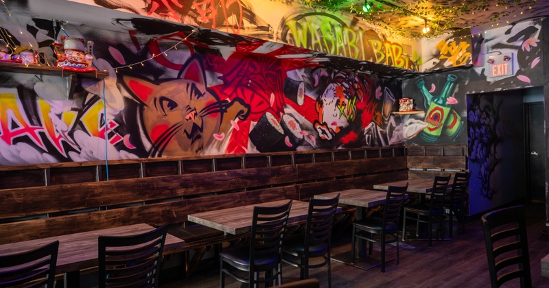 Interior seating area with chairs and tables, and wall murals