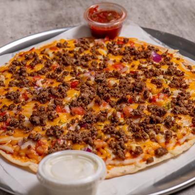 Pizza topped with ground beef, cheese, onions, and tomatoes.