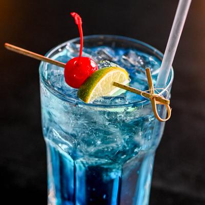 Rum Punch glass garnished with a cherry and lime wedge.