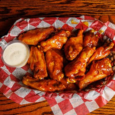 Buffalo wings served with a side of dipping sauce.