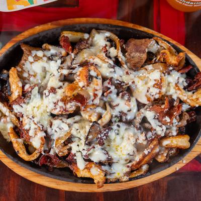 Chicken, steak, and shrimp Fajitas, with bacon, onions, and cheese.