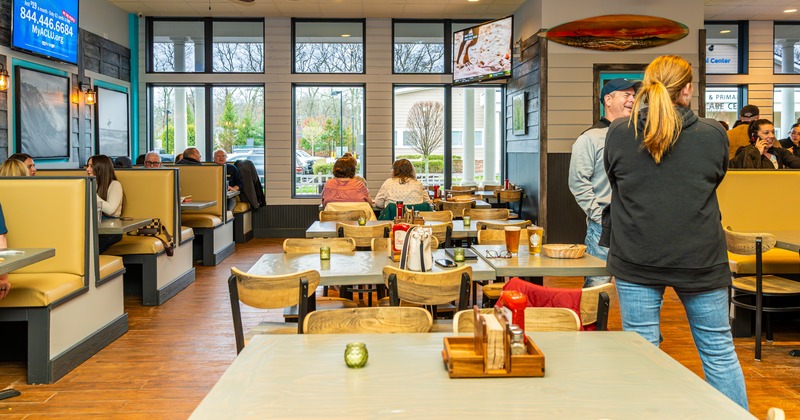 Diner area, tables and chairs, people seating, eating