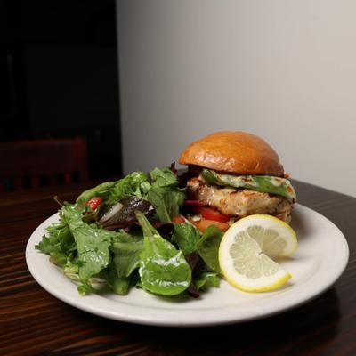Grilled Chicken Sandwich on brioche bun  with side salad.