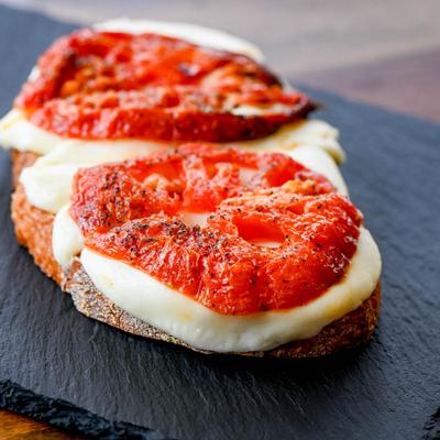 Cheesy toast, with tomatoes.