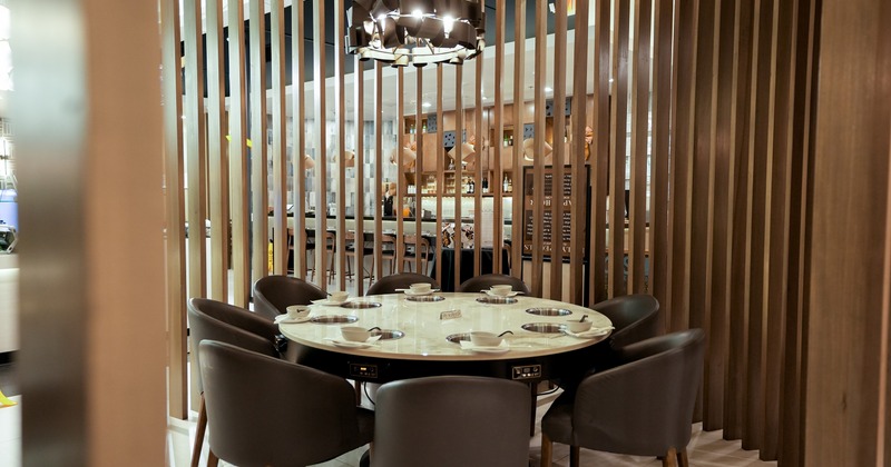 Round dining table for eight guests equipped with built-in hot pot burners