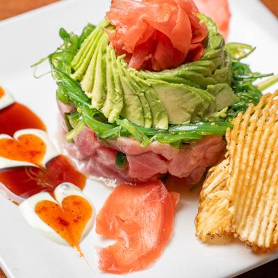 Ahi Tina Poke, served in a tower presentation with avocado and potato waffer.