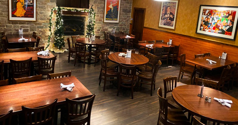 Dining room with wooden tables, wall art, and festive lights