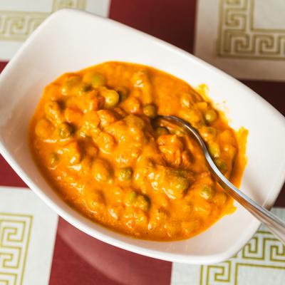 Vegetable korma served in a white bowl.