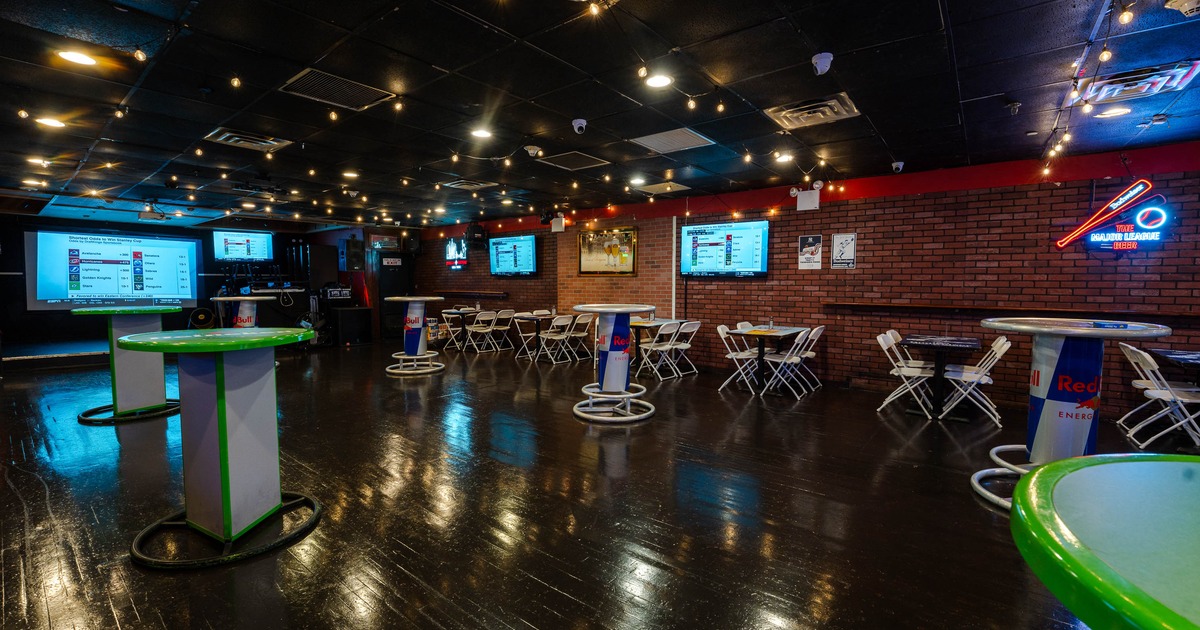 Interior - wooden floors, string lights, branded tables; brick walls, neon signage and TVs