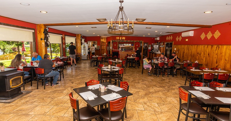 Restaurant interior, dining area with set tables, guests enjoying their food and drinks