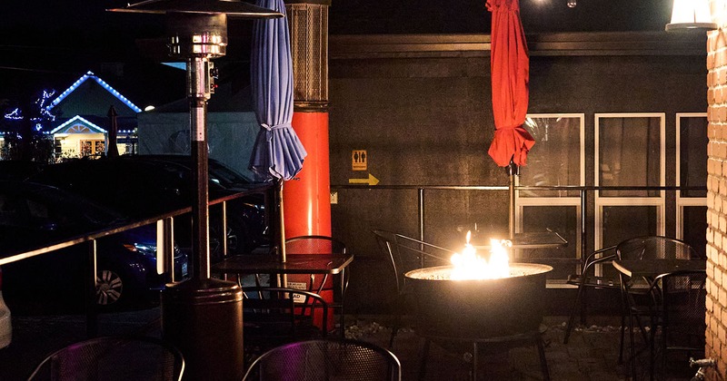 Exterior, patio at night with tables and pit fire