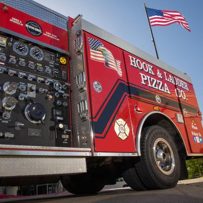 Hook and Ladder Pizza Co fire truck side view.