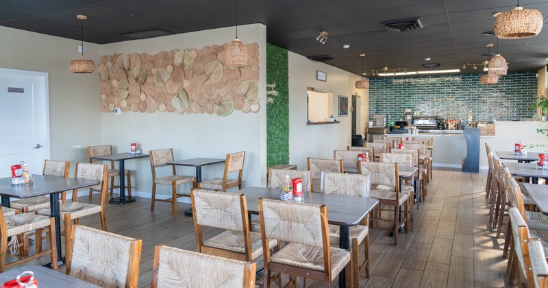 Interior with wooden tables and wicker chairs, decorated walls