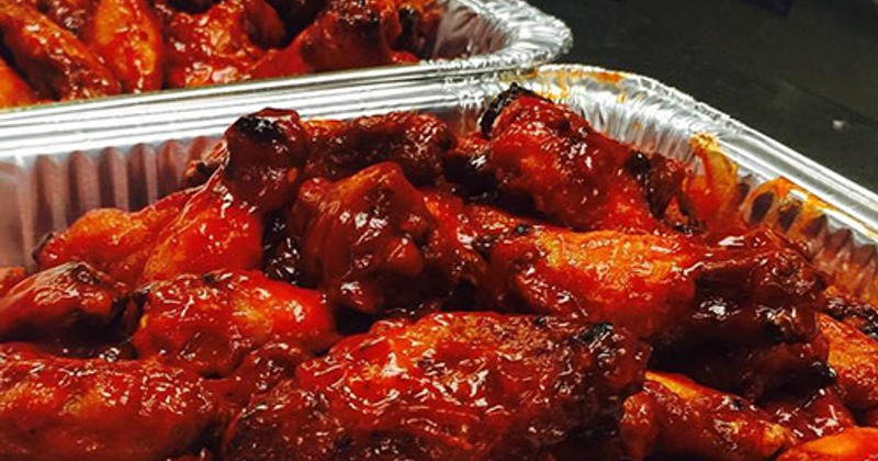 Trays of glazed barbecue chicken wings
