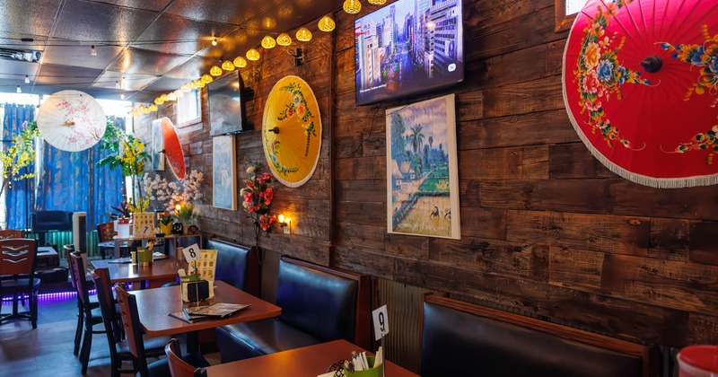 Restaurant interior with wooden walls, colorful parasols, and string lights