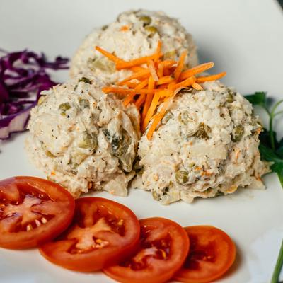Salad Oliviyeh appetizer (Chicken Salad) with sliced tomato garnish..