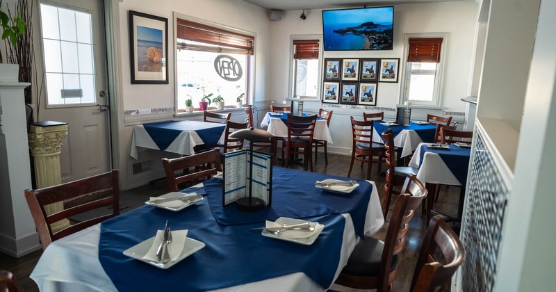 Interior seating area with blue and white table settings and wooden chairs