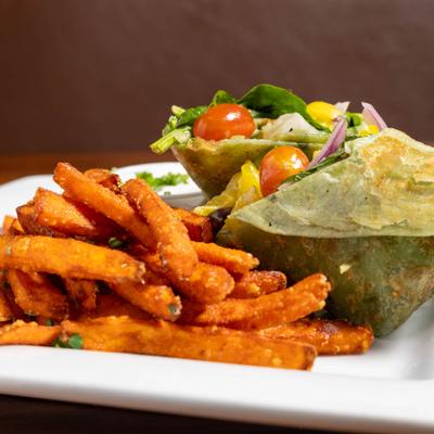 Veggie wrap with sweet potato fries on the side.