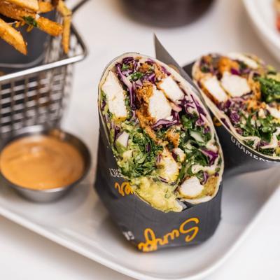 Grilled chicken wrap with cabbage, squash, and greens, served with fries and dipping sauce.