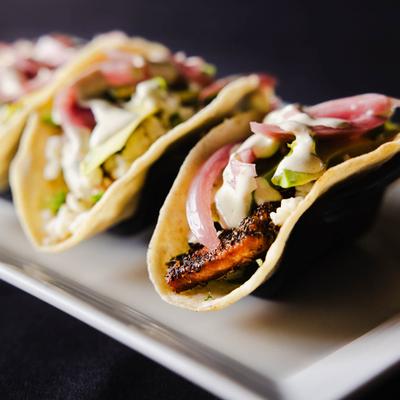 Salmon tacos, served, side view, closeup.