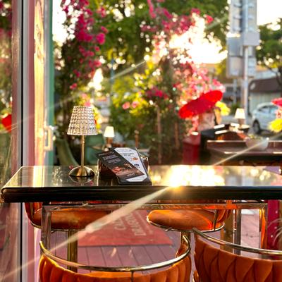 A view of a table at the terrace an a sunshine in the back.