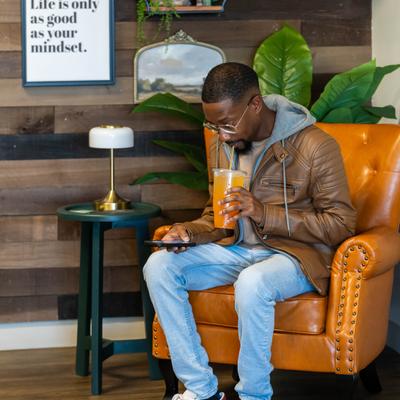 Peron seating in the armchair and having a drink.