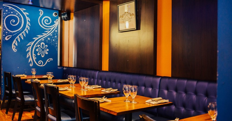 Interior, button tufted leather seating by a wall with tables, table items and chairs