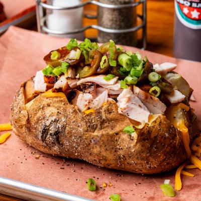 Turkey stuffed potato, topped with cheddar cheese and green onions.