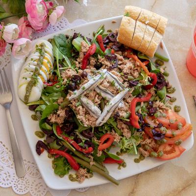 Salad with spring mix, green beans, onion, egg, tuna mix, anchovies, olives, and peppers