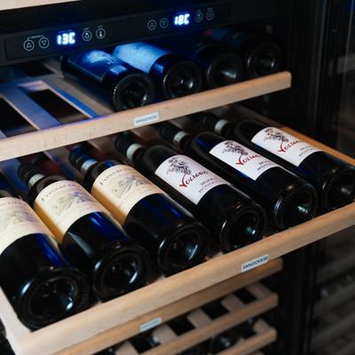 Bottles of red wine on a rack.