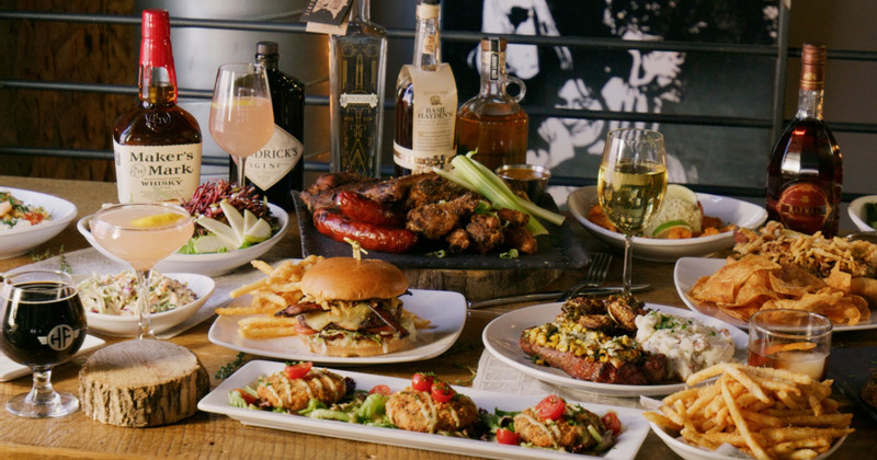 Different dishes on the table with couple of bottles and glasses