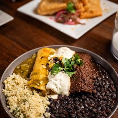 Tres enchiladas with sides of black beans and rice.