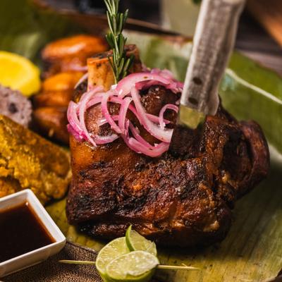 Slow-roasted pork shoulder topped with red onions.