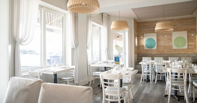 Interior, white tables and chairs, white curtains on windows, rattan pendant lights
