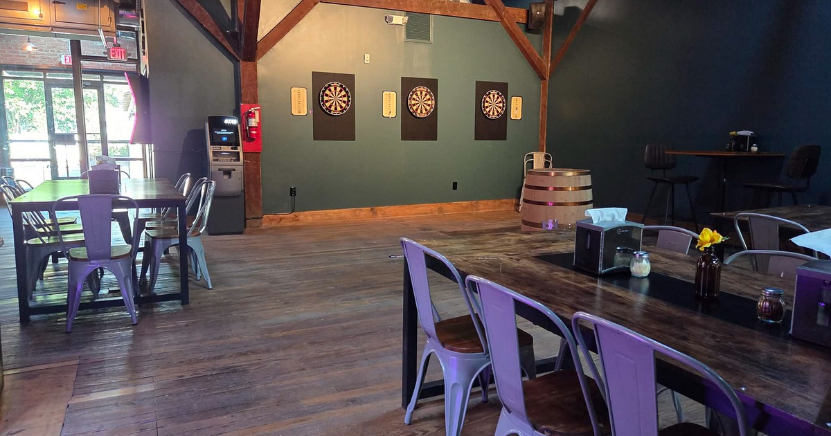 Cozy interior seating area, large dining tables near the dart boards area