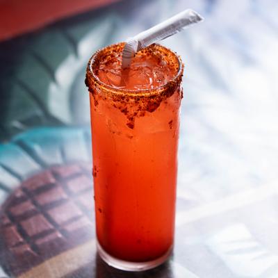 Vampiro cocktail served in a chili-rimmed highball glass.